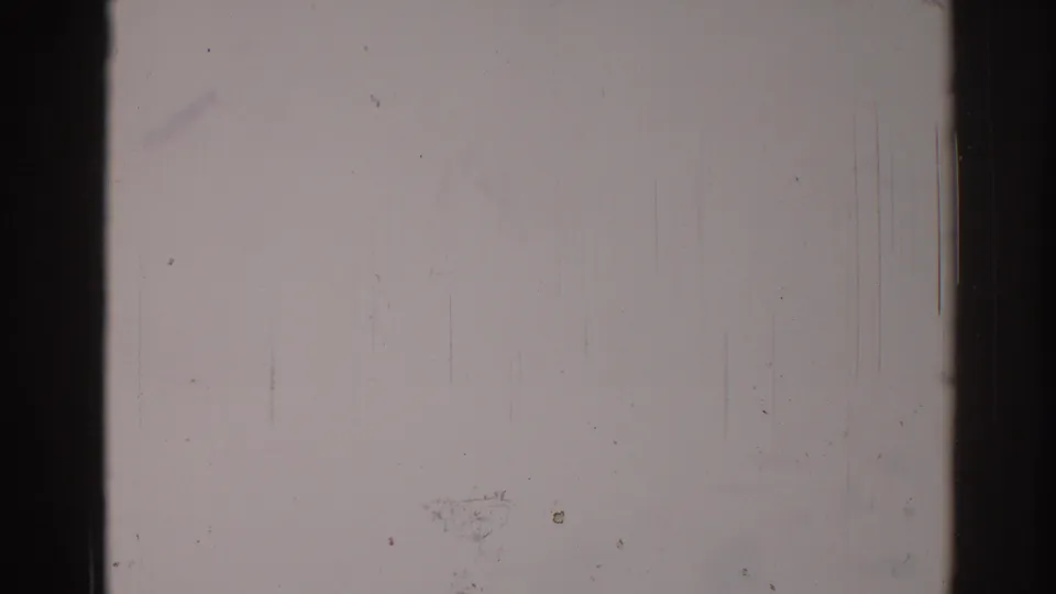 1967 Los Angeles 8mm frame appearing almost blank from overexposure, with dark borders, scratches, dust, and subtle color staining.