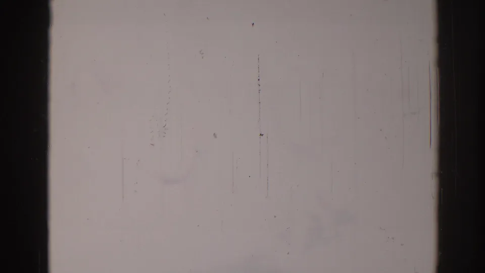 Faded 8mm frame from the 1967 Los Angeles clip, nearly blank with vertical scratches, dust, and dark film borders.