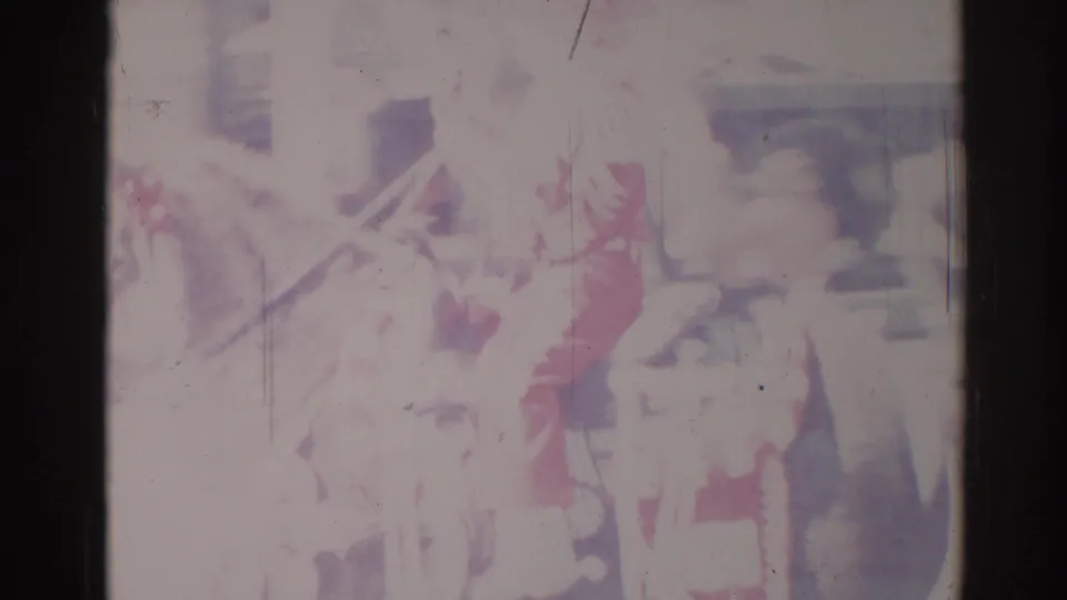 Faded 1967 Los Angeles frame with a horse and rider passing through a sunlit street, seen through scratched 8mm film.