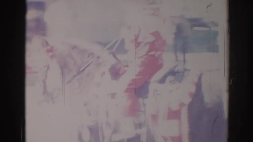 1967 Los Angeles home-movie frame showing a faded parade view with a possible horse rider, festive shapes, and heavy 8mm film wear.