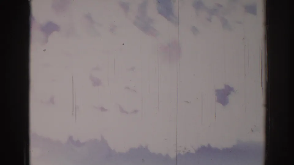 Faded 1967 Los Angeles parade frame with a possible rider or passing figure, pale background, scratches, and dark lower silhouettes.