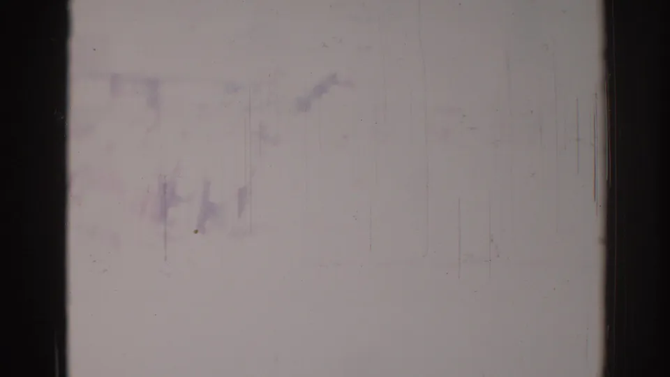 Faded 8mm frame from the Los Angeles clip with only vague traces of the scene and prominent film wear visible.