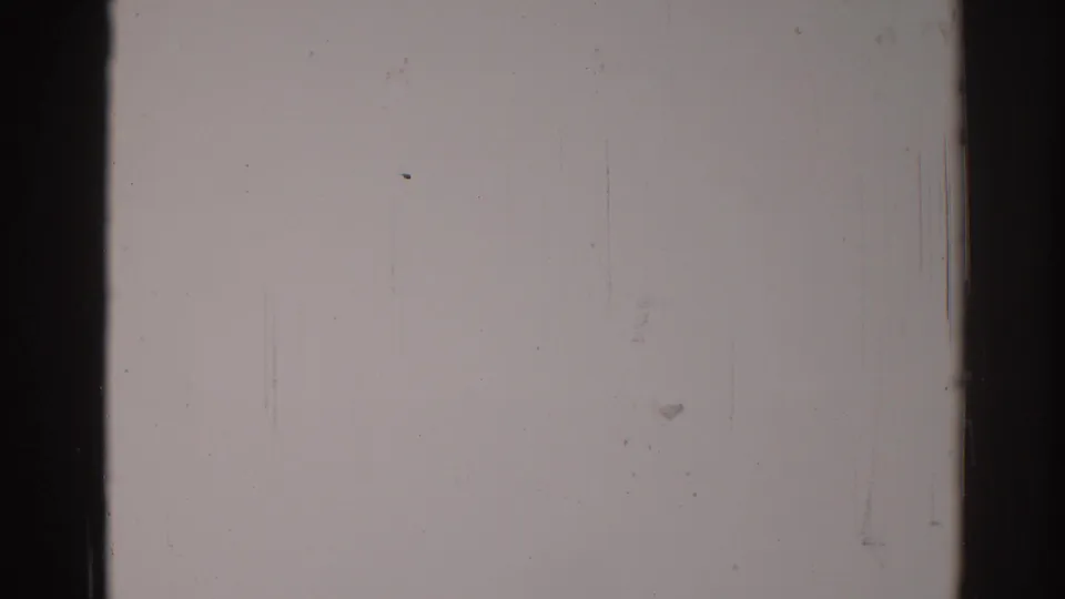 1967 Los Angeles 8mm reel frame showing mostly pale film surface, dark frame edges, dust, grain, scratches, and a central divider.