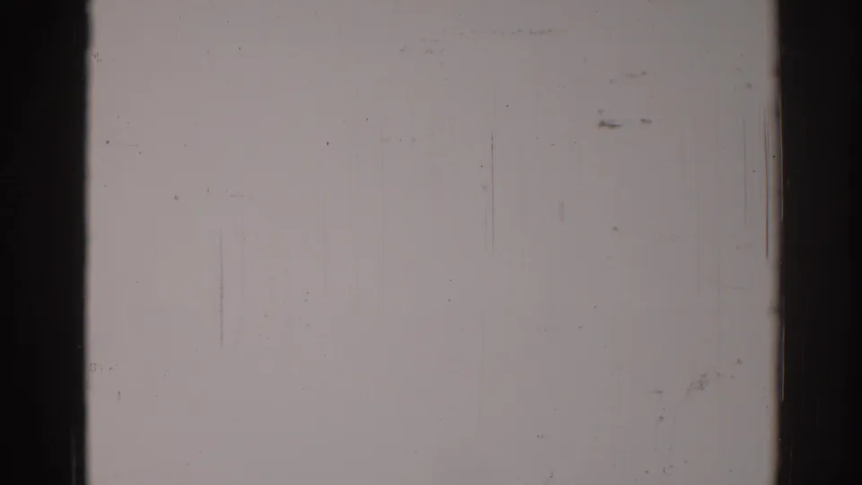 1967 Los Angeles 8mm frame with a nearly blank gray field, visible film edges, scratches, specks, and analog grain.