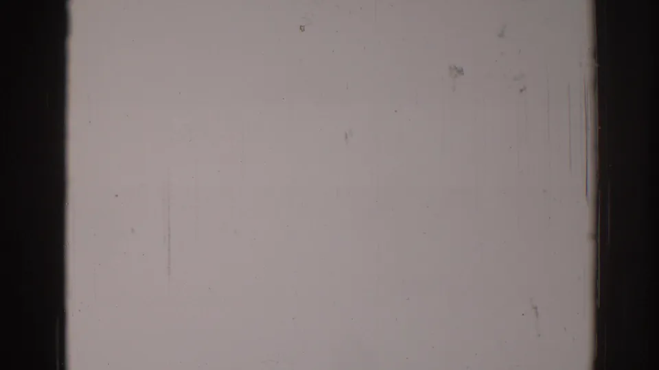 Blank 1967 Los Angeles 8mm home-movie frame with dark edges, vertical scratch marks, dust specks, and uneven exposure.