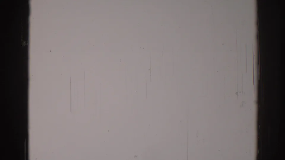 1967 Los Angeles 8mm frame showing a blank pale field, dark right edge, fine vertical scratches, dust, and analog grain.