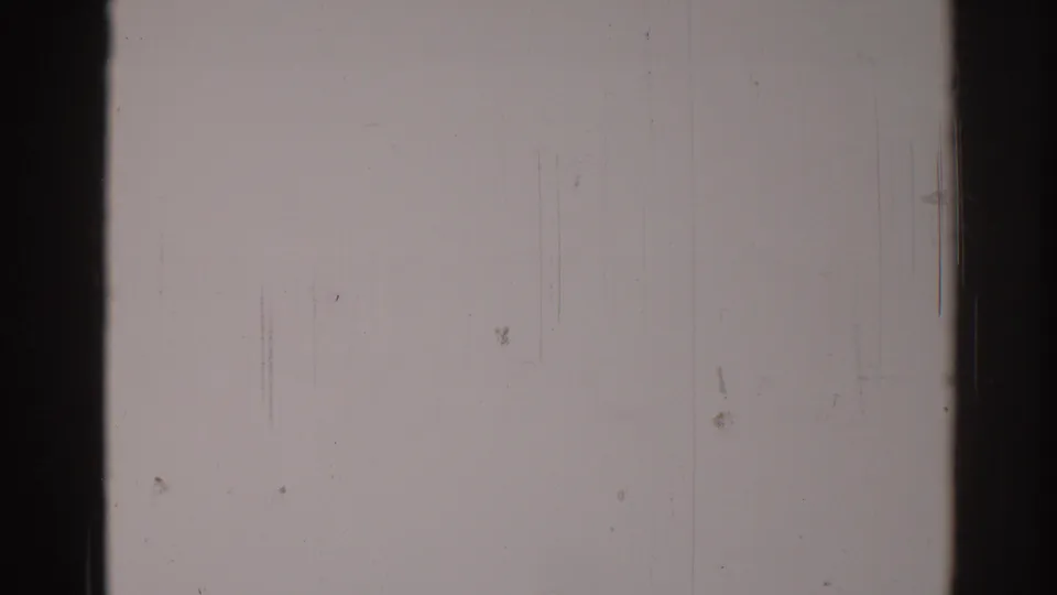 Blank 1967 8mm home-movie frame from Los Angeles with dark film borders, fine vertical wear marks, dust spots, and muted exposure.