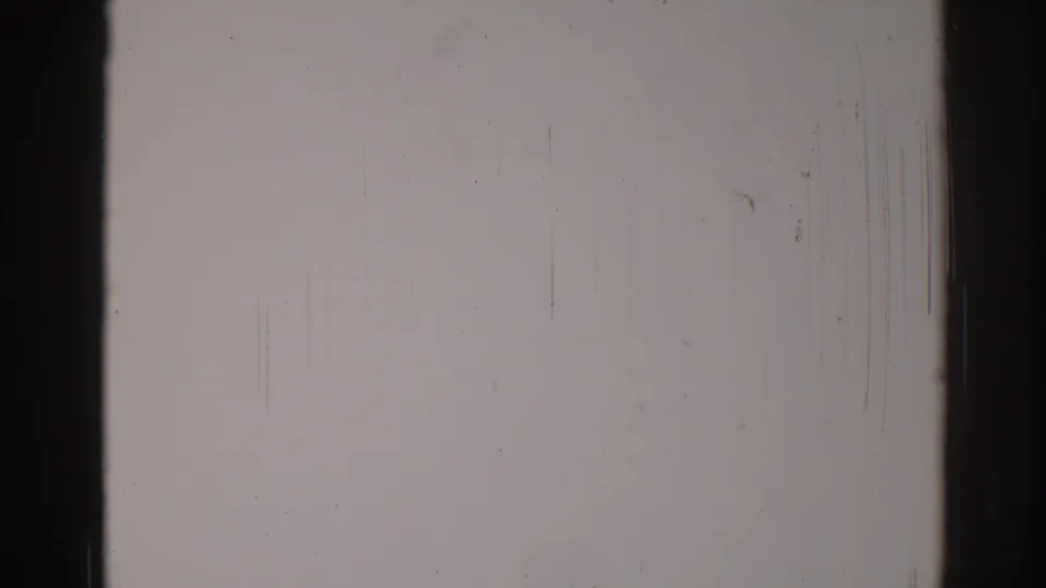 1967 8mm home-movie frame from Los Angeles showing blank pale film area, dark gate edges, scratches, dust, and grain.
