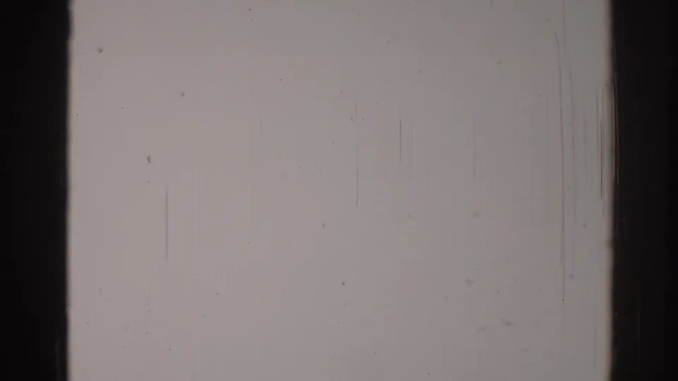 1967 Los Angeles 8mm frame showing a blank damaged film surface with dark gate borders, dust, scratches, grain, and slight tonal banding.