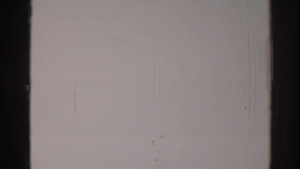 1967 8mm blank film frame from Los Angeles metadata, showing dark gate borders, dust, scratches, grain, and uneven exposure.