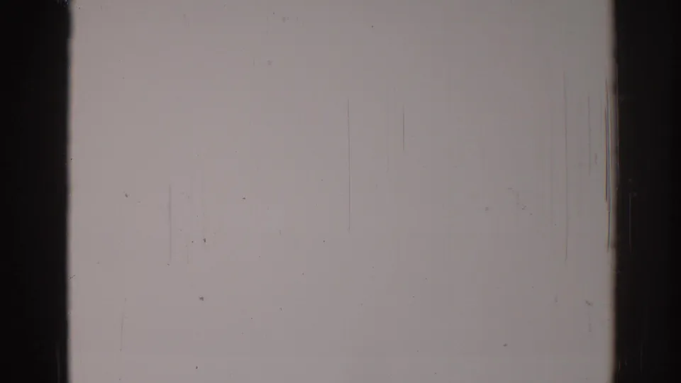 Blank 8mm frame from the 1967 Los Angeles clip, with a dark border, pale film field, dust marks, and fine vertical scratching.