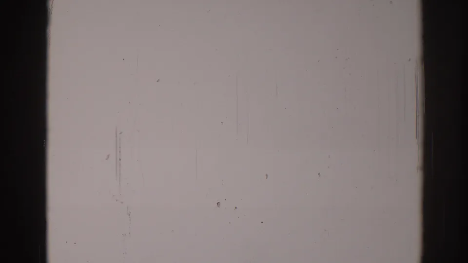 Blank 8mm film frame from 1967 Los Angeles metadata, marked by dust specks, vertical scratches, gate borders, and aged grain.