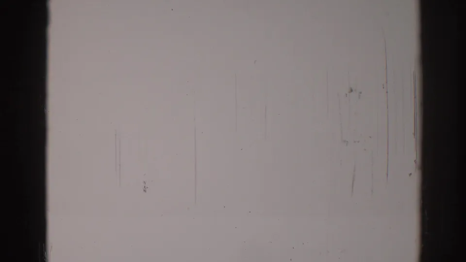 1967 Los Angeles 8mm frame with a muted gray surface, dark edge bands, faint scratches, and scattered dust marks.