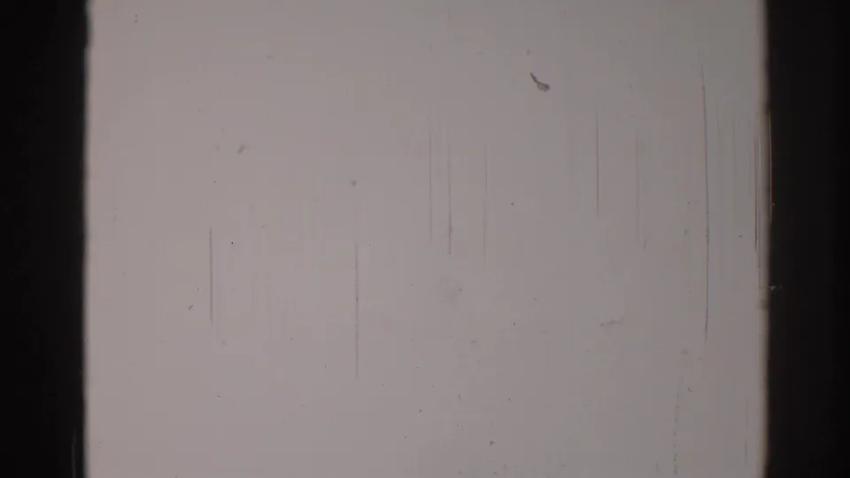 1967 Los Angeles 8mm frame showing gray film texture, a dark central divider, fine vertical wear, and small specks.