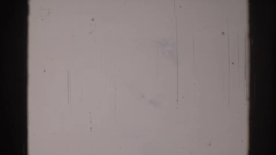 Hazy 1967 Los Angeles 8mm frame with pale overexposure, vertical scratches, dust specks, and dark film-edge borders obscuring the scene.