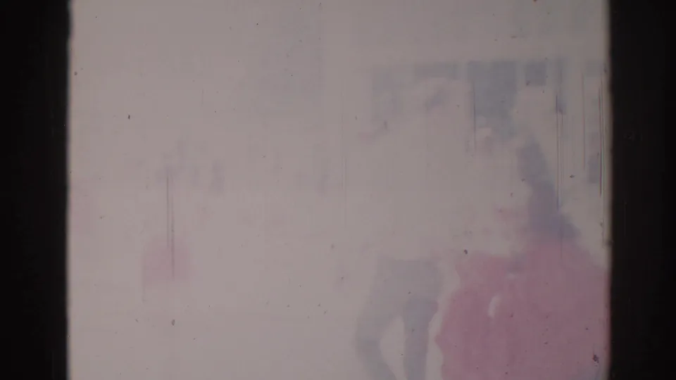 Soft 1967 Los Angeles parade frame with a pink-clad figure near the right edge and faint background shapes through faded 8mm color.