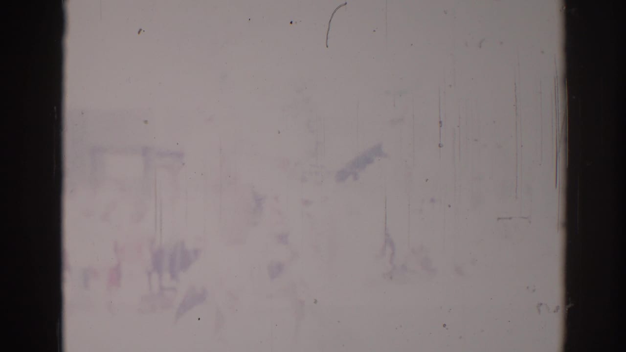 Faded parade frame with an indistinct horseback rider shape and dark film borders.