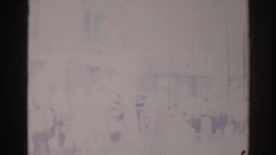 Soft, faded Los Angeles parade frame from 1967 with indistinct spectators or signs visible through scratches and overexposure.