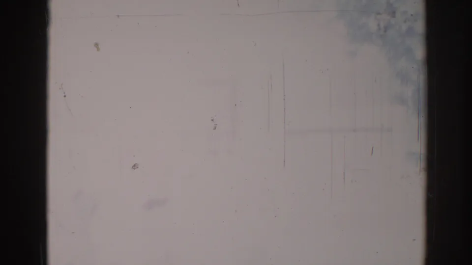 1967 Los Angeles 8mm frame with faint foliage near the upper right, a washed pale field, dark film border, dust, and vertical abrasion.