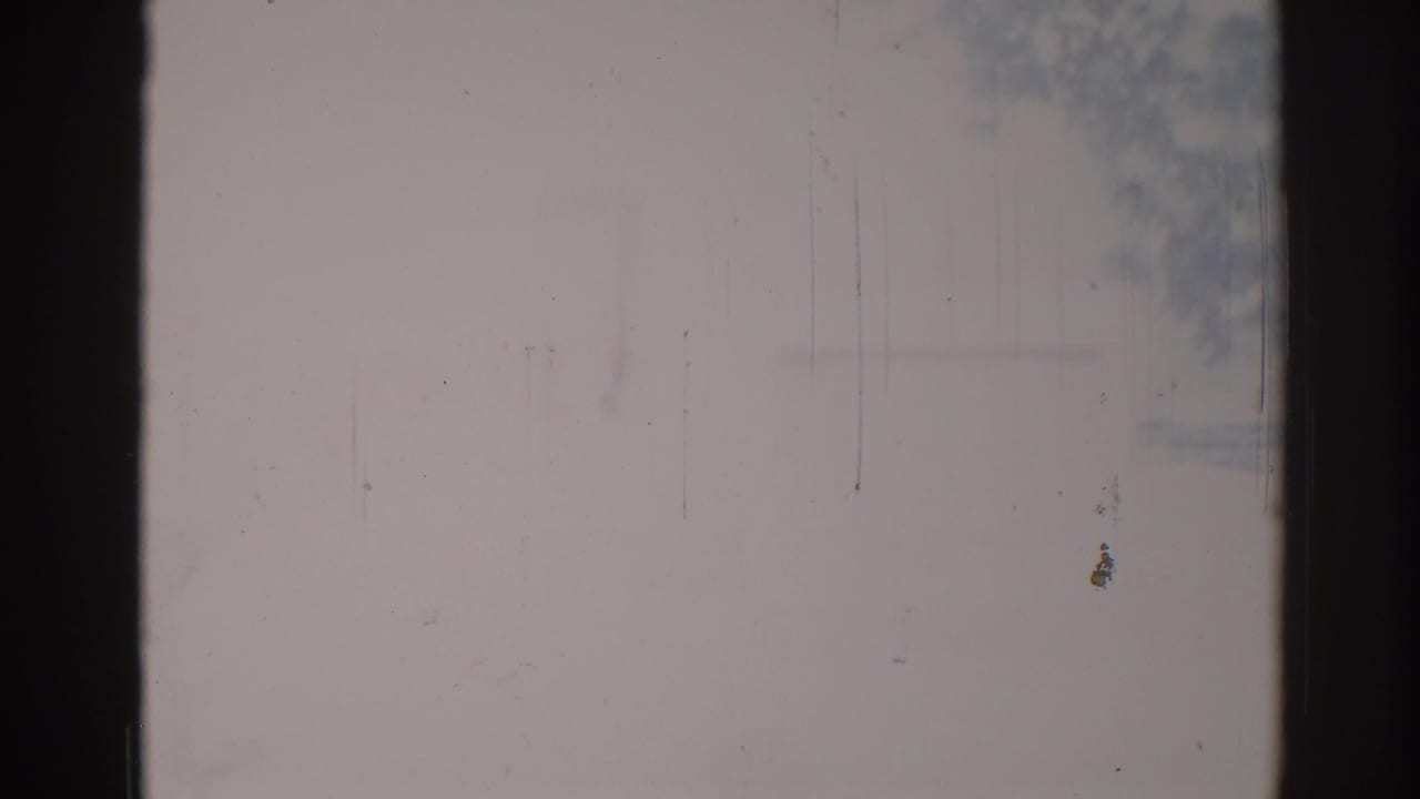 Overexposed pale frame with dark side bands and faint marks near the top.