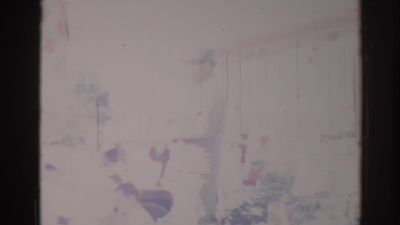 Soft, faded parade scene with a partially visible decorated float and dark film borders.