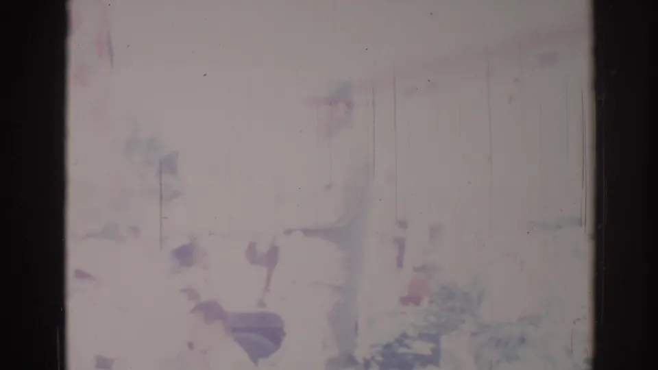 Faded 1967 Los Angeles 8mm frame showing a blurred parade float or decoration from a spectator viewpoint.