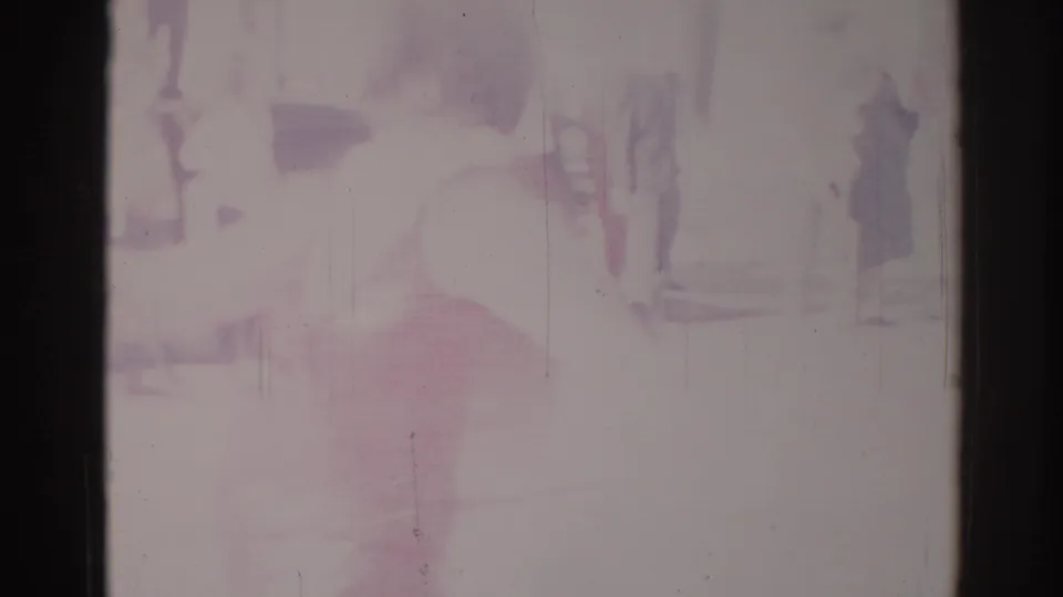 Faded 1967 Los Angeles parade frame with faint pedestrians, bright street exposure, and indistinct urban background.