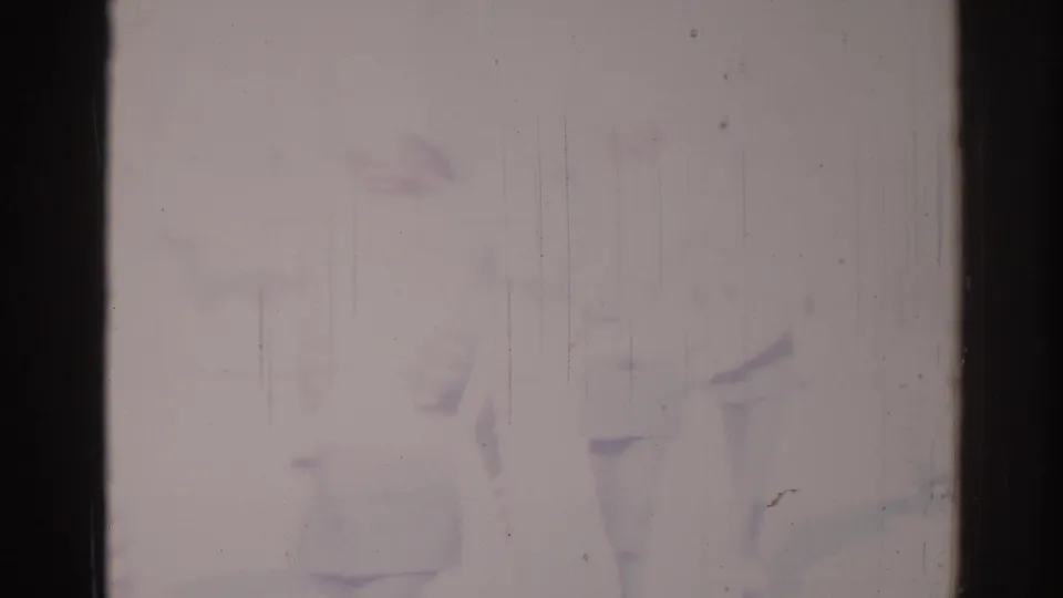 Overexposed 1967 Los Angeles home-movie frame with faint figures, a possible sign, and heavy film wear obscuring detail.