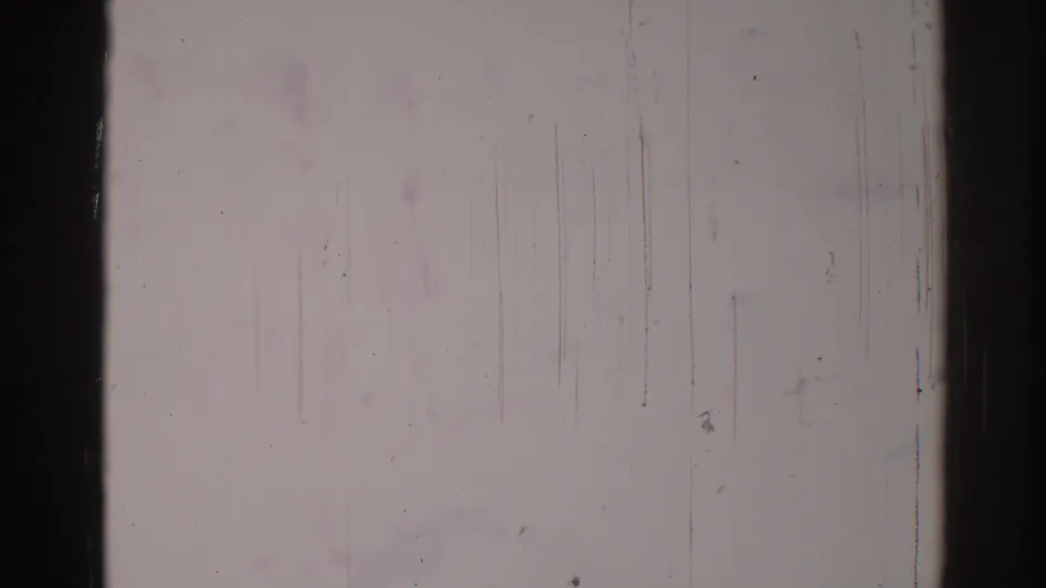 Nearly washed-out 1967 Los Angeles 8mm frame with faint activity traces, dark film borders, and visible surface abrasion.