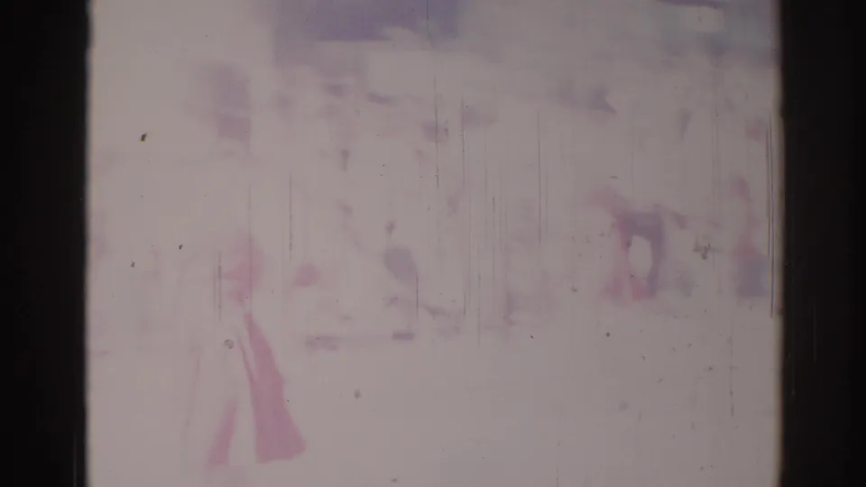 A faint person appears near a pale vehicle shape in washed-out 1967 Los Angeles home-movie footage.