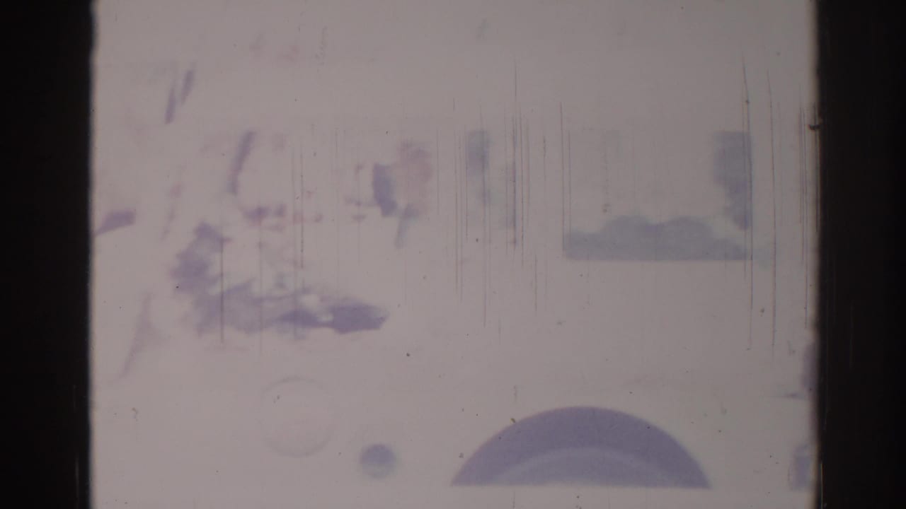 A partial white truck and dark wheel are visible near the lower frame in faded 1967 Los Angeles 8mm footage.