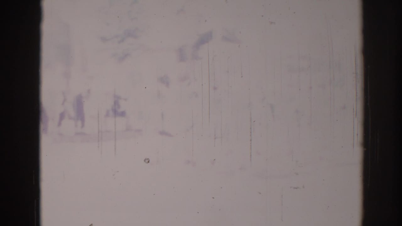 Overexposed 1967 Los Angeles-area home-movie frame showing faint spectators or parade participants near a commercial street.