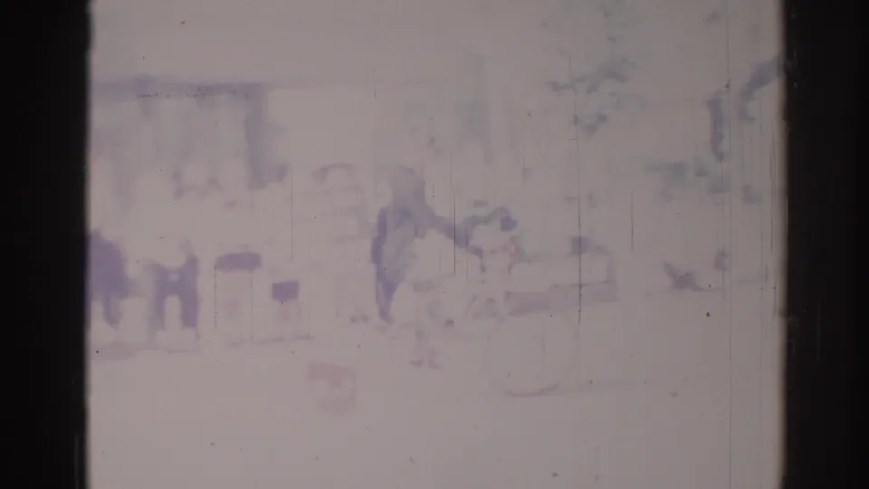 1967 Los Angeles home-movie frame with a faint bicyclist, pedestrians, and street surroundings softened by faded 8mm exposure.
