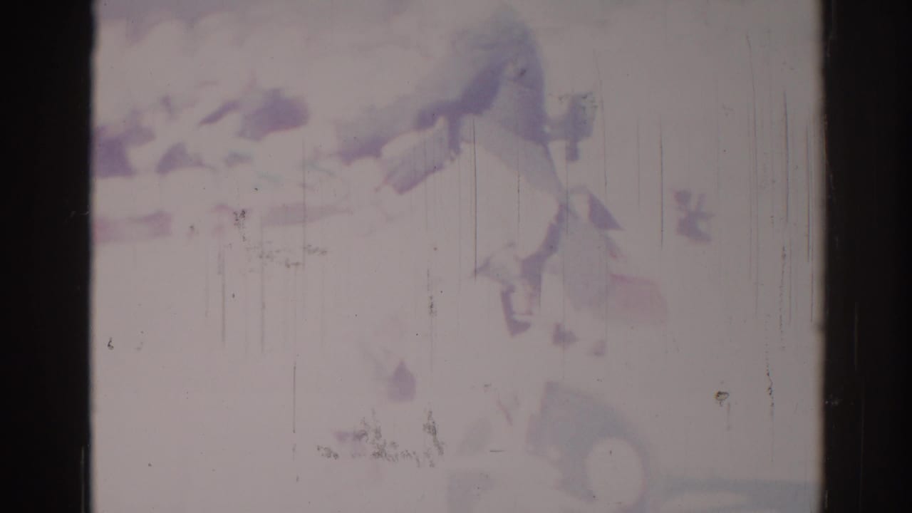 1967 Los Angeles home-movie frame with a soft bicyclist or delivery rider form at right, seen through faded color and scratches.
