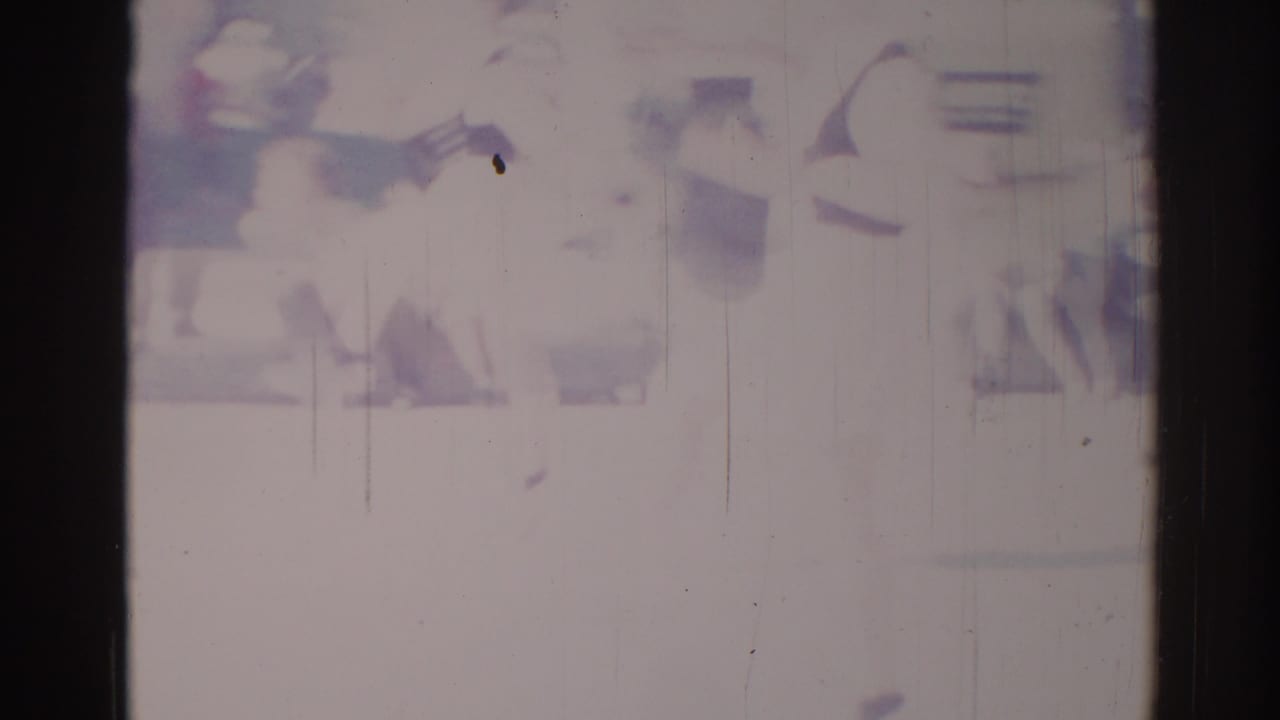 Soft, overexposed 1967 Los Angeles frame with dark performer-like shapes, possible equipment, and visible film wear.