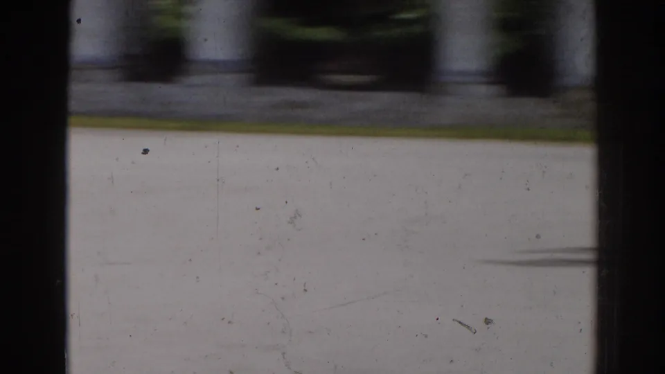 A quiet section of the Moscow park scene shows pale paving, classical columns, and shaded greenery on 8mm film.