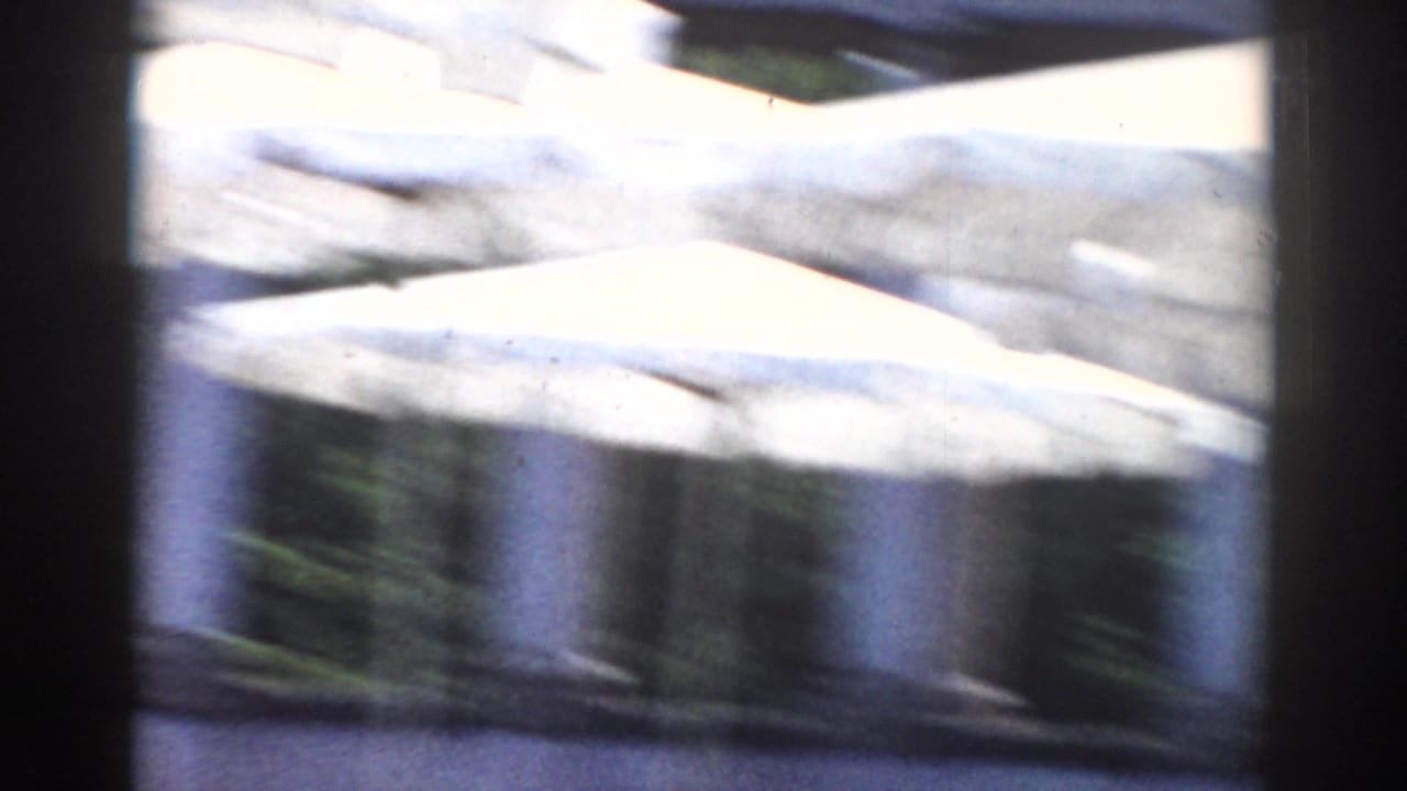 Blurred outdoor canopy and columned structure seen from a moving camera.