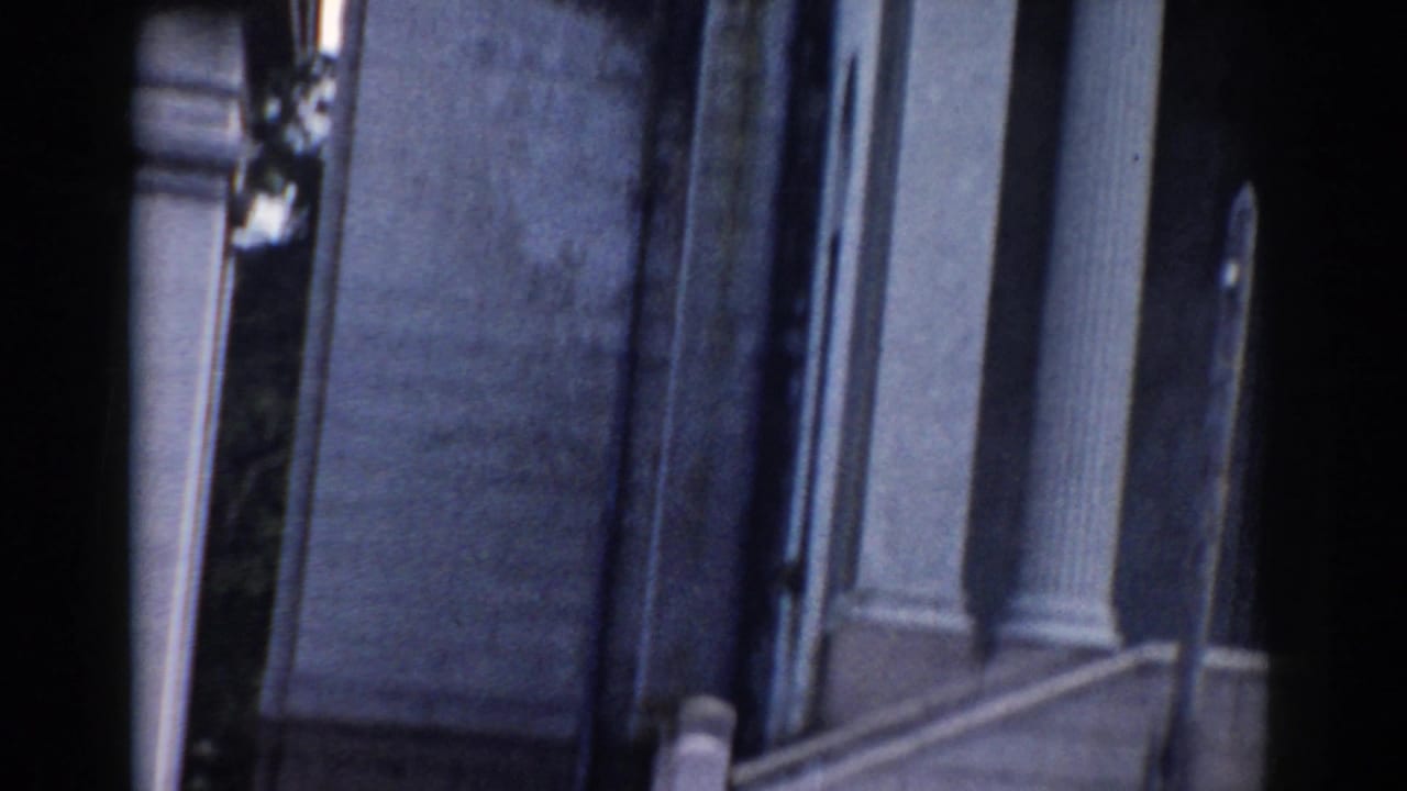 Columned building facade and dark foreground edge in soft focus.