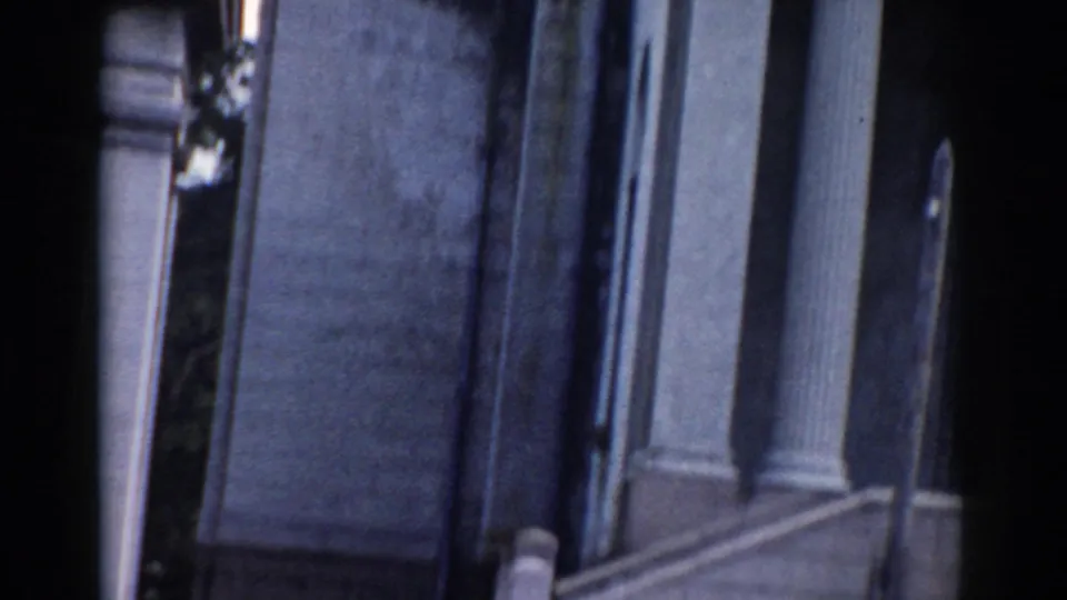 Handheld 8mm view of a columned exterior in Moscow, with a dark vertical edge crossing the frame.