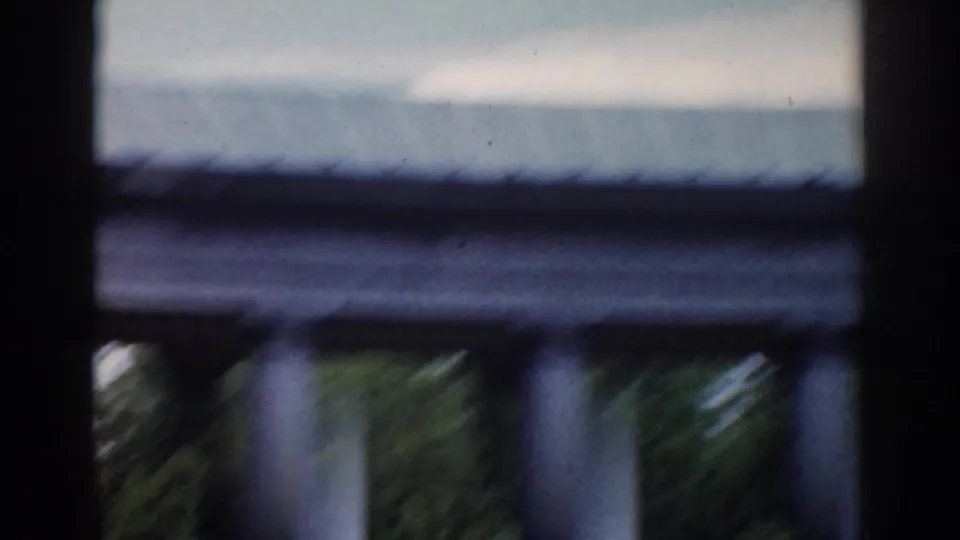 A motion-blurred 1968 Moscow home-movie frame catches the awning, railing, and greenery around the outdoor setting.