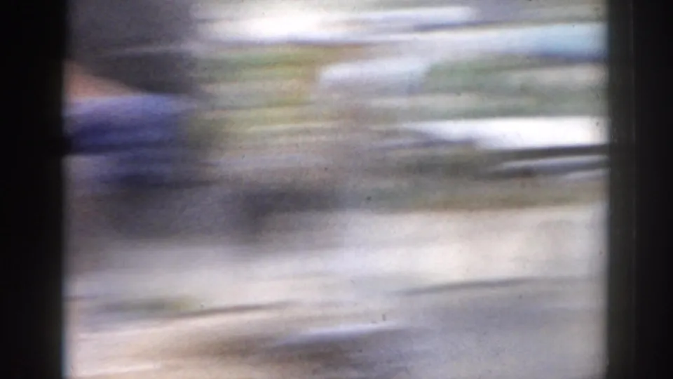 Soft, blurred opening frame from an 8mm home movie, with lateral motion and dark frame edges obscuring the scene.