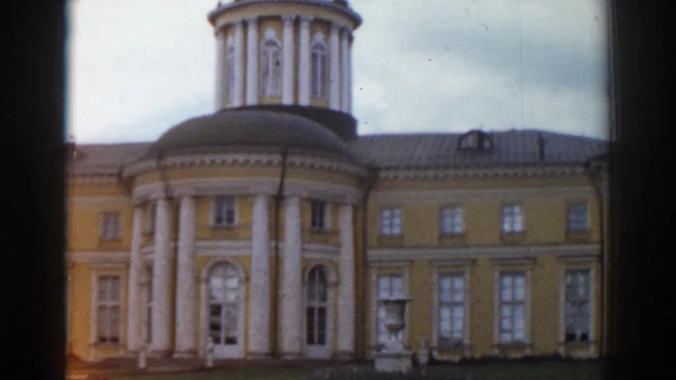 1968 Moscow frame showing a yellow classical-style building with a columned rotunda, tall windows, lawn, and a garden statue.
