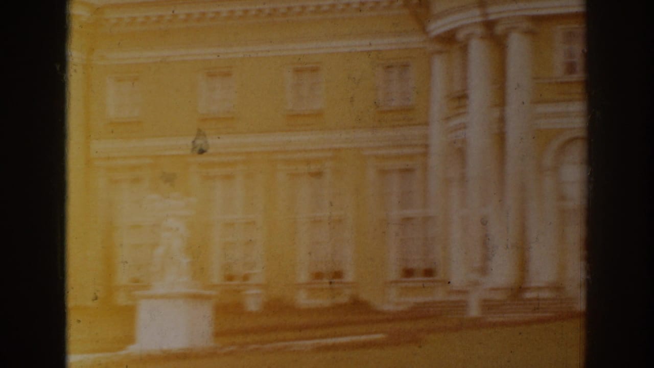 Overexposed yellow building facade with columns, windows, steps, and dark frame edge.