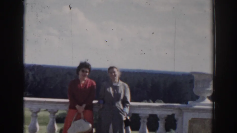 A 1968 Moscow home-movie frame shows two women posing at a formal overlook, framed by a balustrade and distant trees.