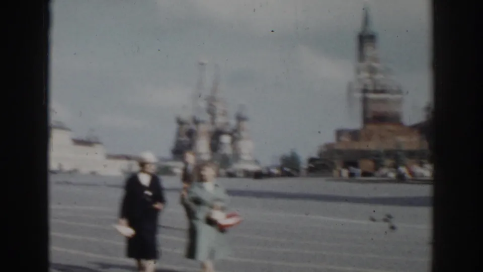 In 1968 Moscow footage, two women move across Red Square while St. Basil's Cathedral rises in soft focus behind them.