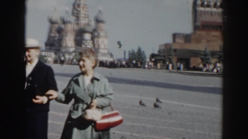 Older visitors in Moscow's Red Square walk and gesture near St. Basil's Cathedral, captured in soft 8mm color footage.
