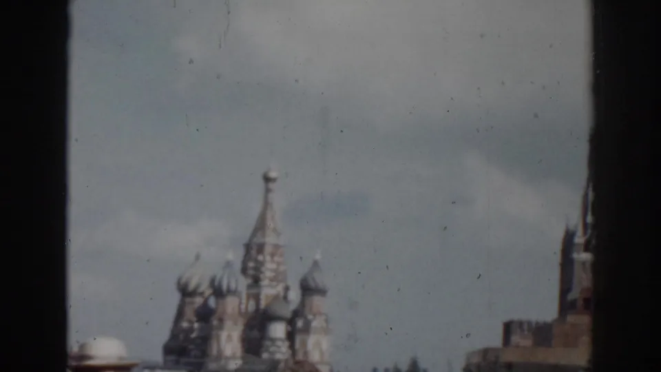 Softly framed 1968 Moscow travel view showing St. Basil's Cathedral and a nearby tower across the open Red Square pavement.