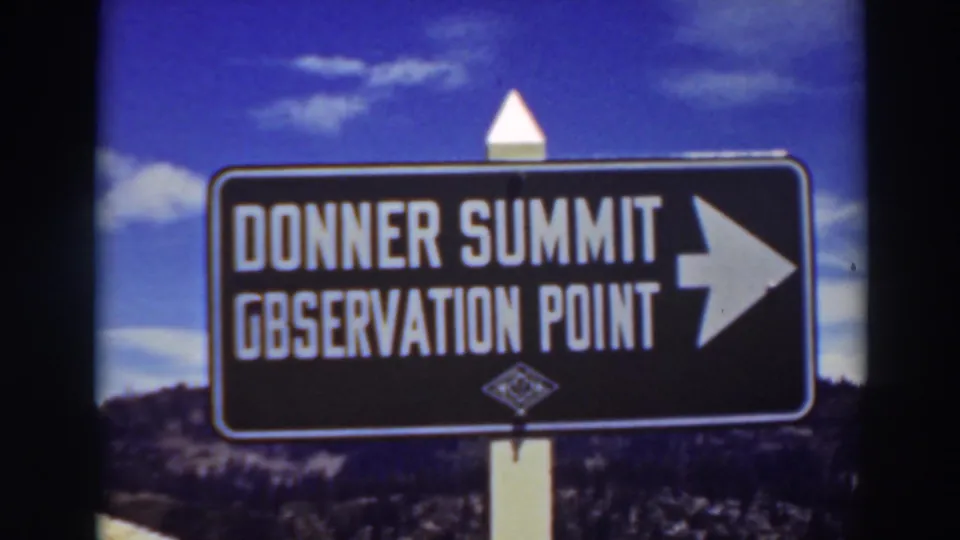 Lake Tahoe-area home-movie frame from 1937 showing the Donner Summit Observation Point sign under a saturated blue sky.