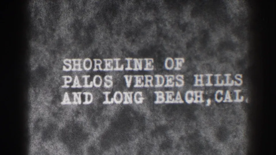 1937 8mm title card reading Shoreline of Palos Verdes Hills and Long Beach, Cal. on a dark textured background.