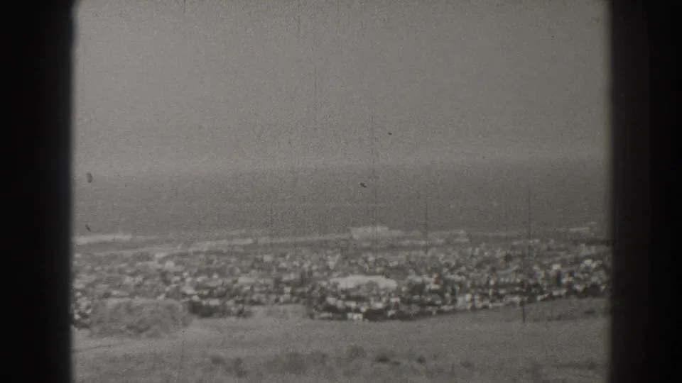 A soft 8mm view across Long Beach toward the shoreline and Pacific, with a dark vertical obstruction in the foreground.